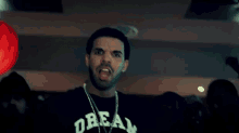 a man wearing a black shirt that says dream 416 on it