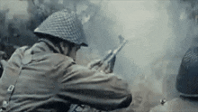 a soldier wearing a helmet is holding a gun in a battle .