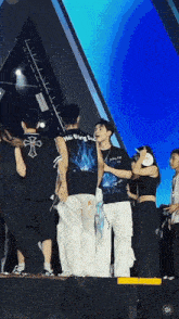 a group of people are standing on a stage and one of them is wearing a shirt that says hai dang dea