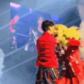 a man in a red jacket is standing next to a woman in a red coat