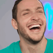 a man with a beard is laughing with his mouth wide open