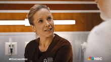 a woman in a chicago medical scrub talking to a man