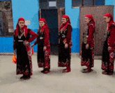 a group of women dressed in traditional clothes are standing in a row