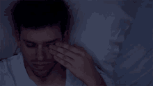 a man is laying in bed with his eyes closed