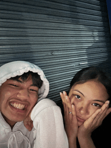 a boy and a girl are posing for a picture and the girl has a ring on her finger