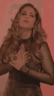 a woman in a black dress is making a funny face with her hands in the air .