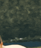 a shirtless man is standing in front of a swimming pool .