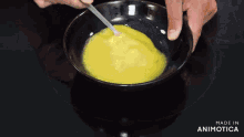 a man is stirring a bowl of food on a stove with the words made in animatica on the bottom