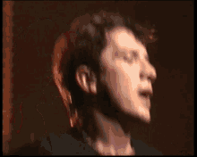 a man is singing into a microphone with a sticker on it