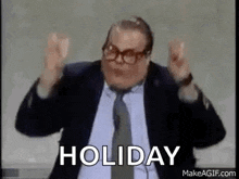 a man in a suit and tie is making a funny face with his hands in the air .