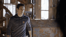 a man wearing a grey hoodie with the letter s on it