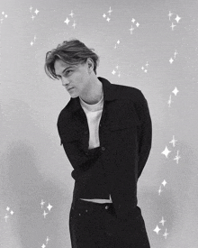 a black and white photo of a man in a white shirt and black jacket