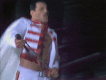 a man without a shirt is singing into a microphone on stage