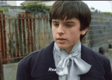 a young boy wearing a bow tie and a jacket says really