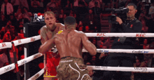 two boxers are fighting in a ring with kfc written on the ring ropes