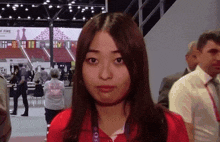 a woman in a red shirt with a lanyard around her neck that says ' fire '