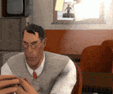 a man wearing glasses sits in front of a bulletin board with a picture of a man on a bike on it