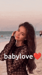 a woman standing on a beach with the word babylove written on the bottom