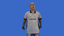 a man wearing a shirt that says minas gives a thumbs up