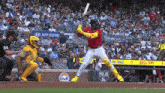 a baseball player swings at a pitch in front of a gulf advertisement