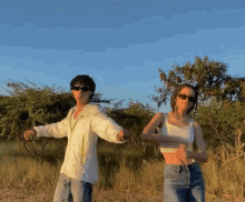 a man and a woman are holding hands in a field