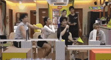 a group of people are gathered in a room with a sign that says ' kpmtv ' on it