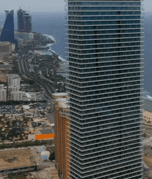 an aerial view of a city with a very tall building in the middle