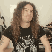 a man with long hair is wearing a shirt that says axxnn
