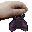 a hand is holding a purple teddy bear with sunglasses on .