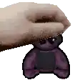 a hand is holding a purple teddy bear with sunglasses on .