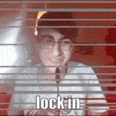 a man with glasses and a microphone behind blinds with the words lock in on the bottom