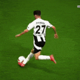 a soccer player with the number 27 on his jersey is running towards another player with the number 6 on his jersey