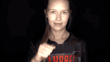 a woman wearing a campbell jersey holds her fist up