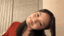 a close up of a woman 's face with a red shirt on
