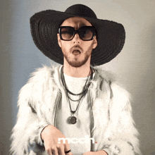 a man wearing a fur coat and a hat with the word mcdn on the bottom right