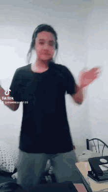 a person wearing headphones is dancing in a bedroom .
