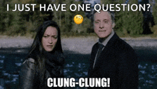 a man and a woman are standing next to each other in front of a river and a river .