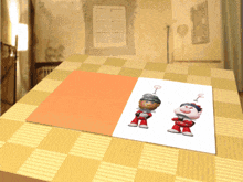 a card with two cartoon characters on it sits on a checkered tablecloth