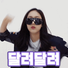 a woman wearing sunglasses and a jacket with a purple sticker that says ' eee ' on it