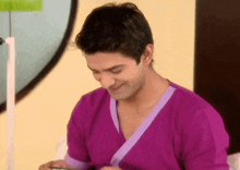 a man in a purple shirt is smiling