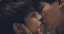 two young men are kissing each other with their eyes closed