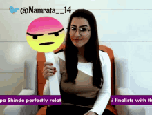 a woman sitting in a chair holding up a smiley face with the name namrata_14 on the bottom