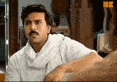 a man with a mustache is wearing a white shirt and a white scarf ..