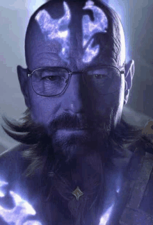 a man with glasses and a beard is wearing a purple shirt and a necklace .