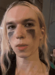 a close up of a person 's face with black paint on it