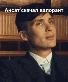 a man in a suit and tie is looking up with a caption in a foreign language that says " ansat "