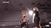 a wrestler with the word ego on his shorts stands in a ring