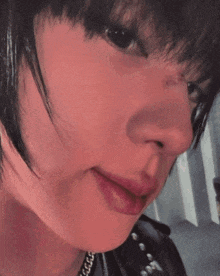 a close up of a person 's face with a black jacket on