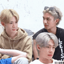 three young men are sitting on a couch and one of them is wearing a hoodie that says soulwar 's on it
