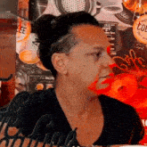 a woman with a bun on her head is sitting in front of a wall with a sign that says coffee .